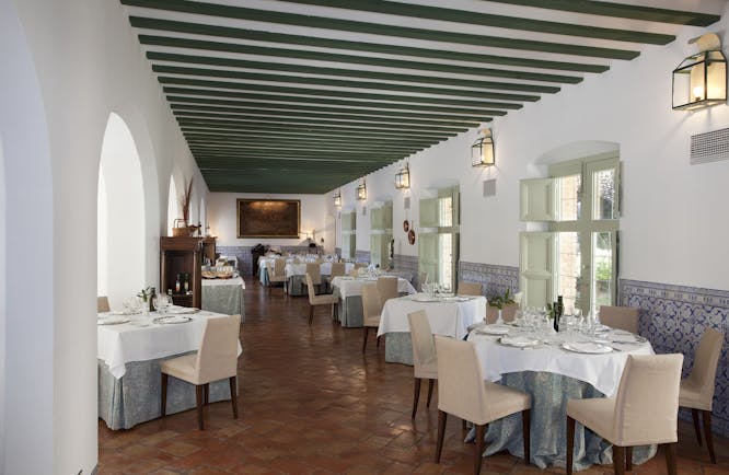 Parador de Almagro restaurant, dining tables, chairs, tiled floor, traditional architecture