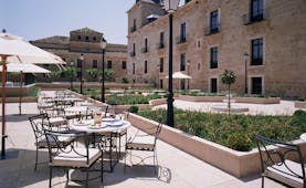 Parador de Lerma terrace, outdoor dinign area, patio, garden beds, hotel building 