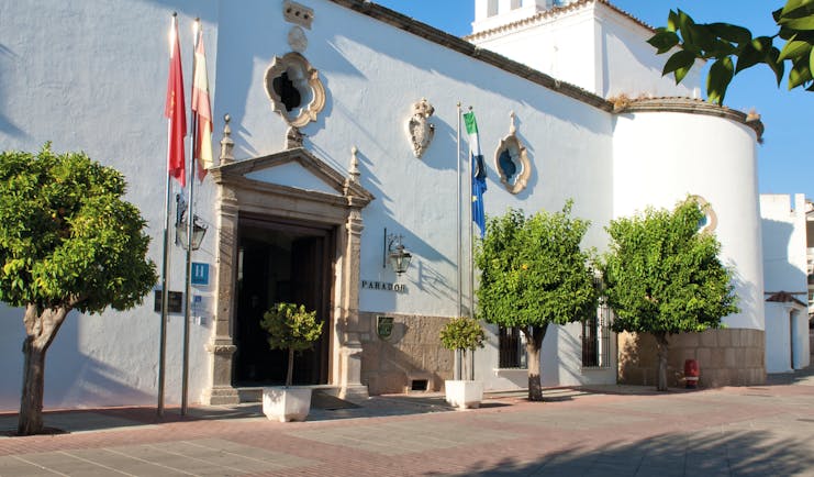 Exterior entrance to hotel showing white stone building with flags outside
