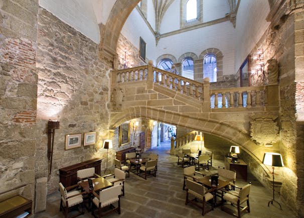 Lobby area with stone walls, seating areas and stairs leading upstairs