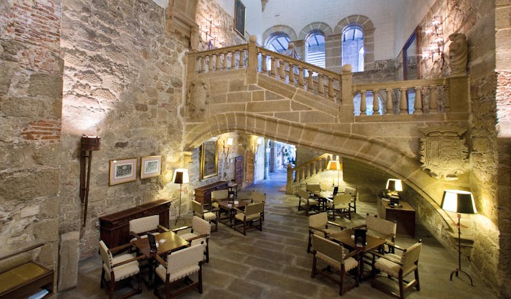 Lobby area with stone walls, seating areas and stairs leading upstairs