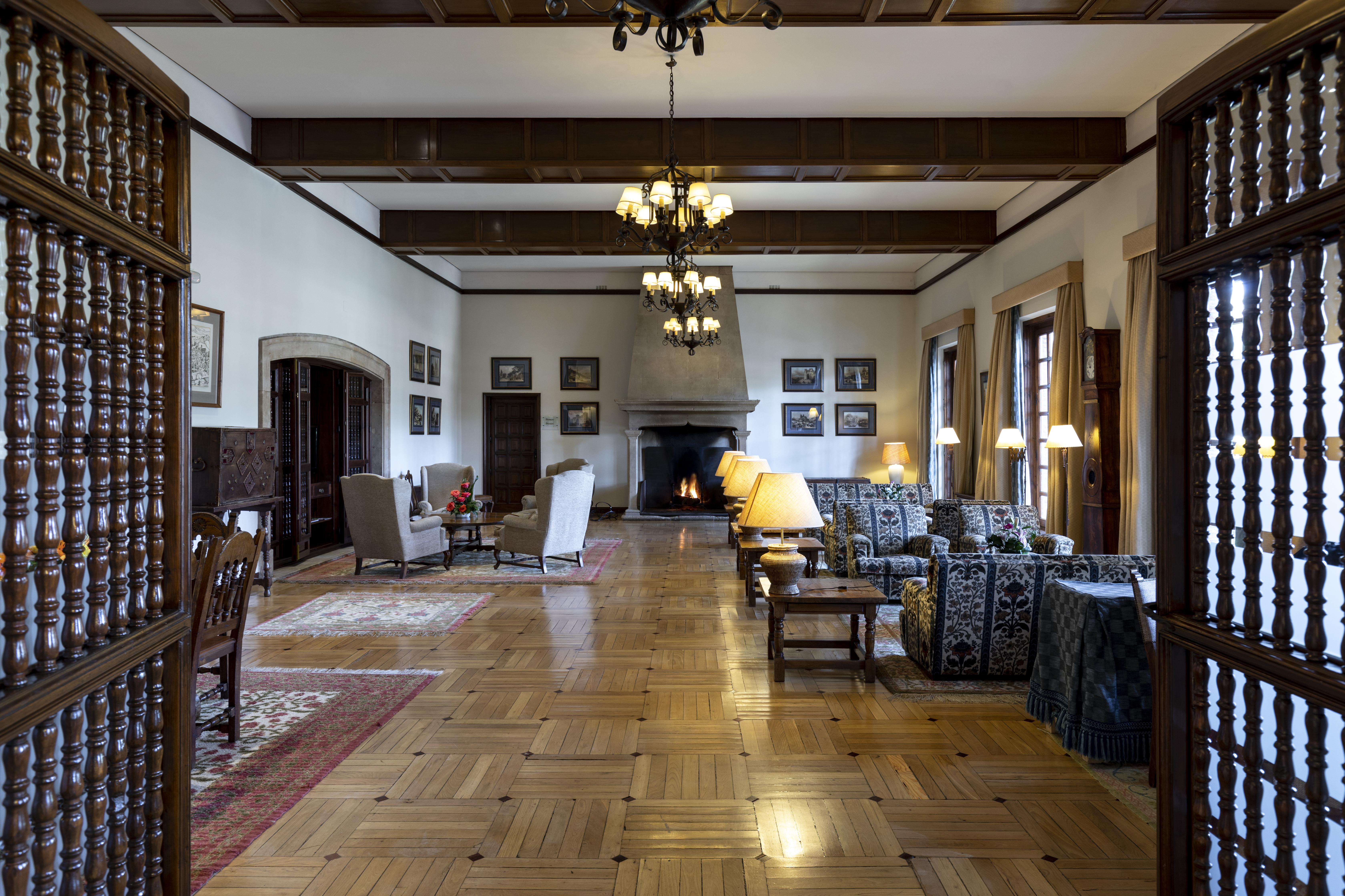 Parador de Tordesillas lounge, traditional decor and architecture, sofas, armchairs, candelabra, open fire