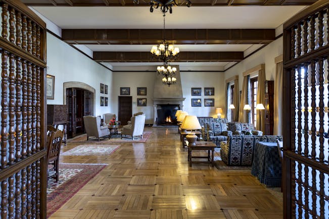 Parador de Tordesillas lounge, traditional decor and architecture, sofas, armchairs, candelabra, open fire