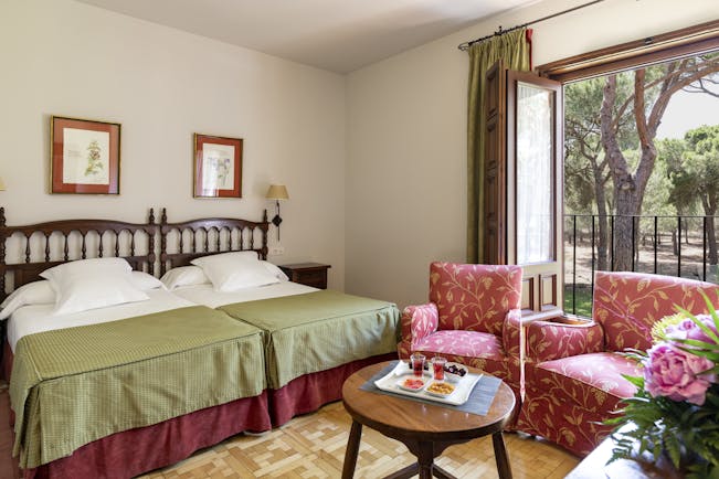 Parador de Tordesillas standard room, twin beds, traditional decor, armchoirs, garden view