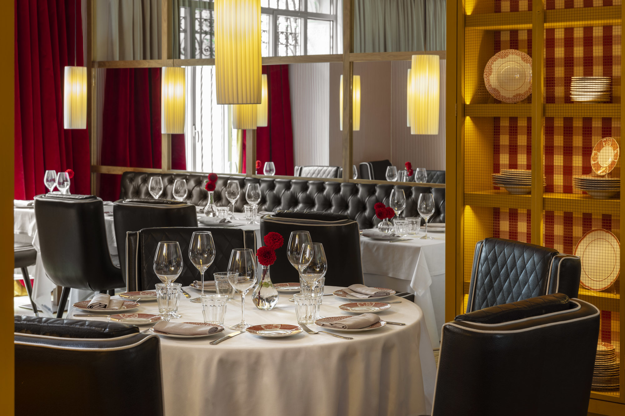 Hotel Urso Casa Felisa Restaurant, with white-clothed tables, low-hanging lights, and warm red decor