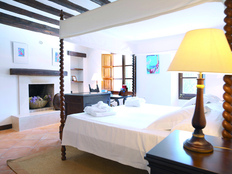 Belmond la Residencia Mallorca bedroom fireplace with four poster bed