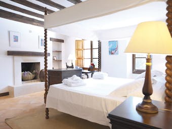 Belmond la Residencia Mallorca bedroom fireplace with four poster bed
