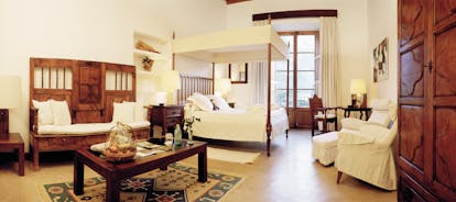 Belmond la Residencia Mallorca bedroom with four poster and wooden bench