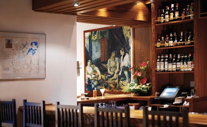 La Residencia Mallorca bar stools wine bottles large painting of three women