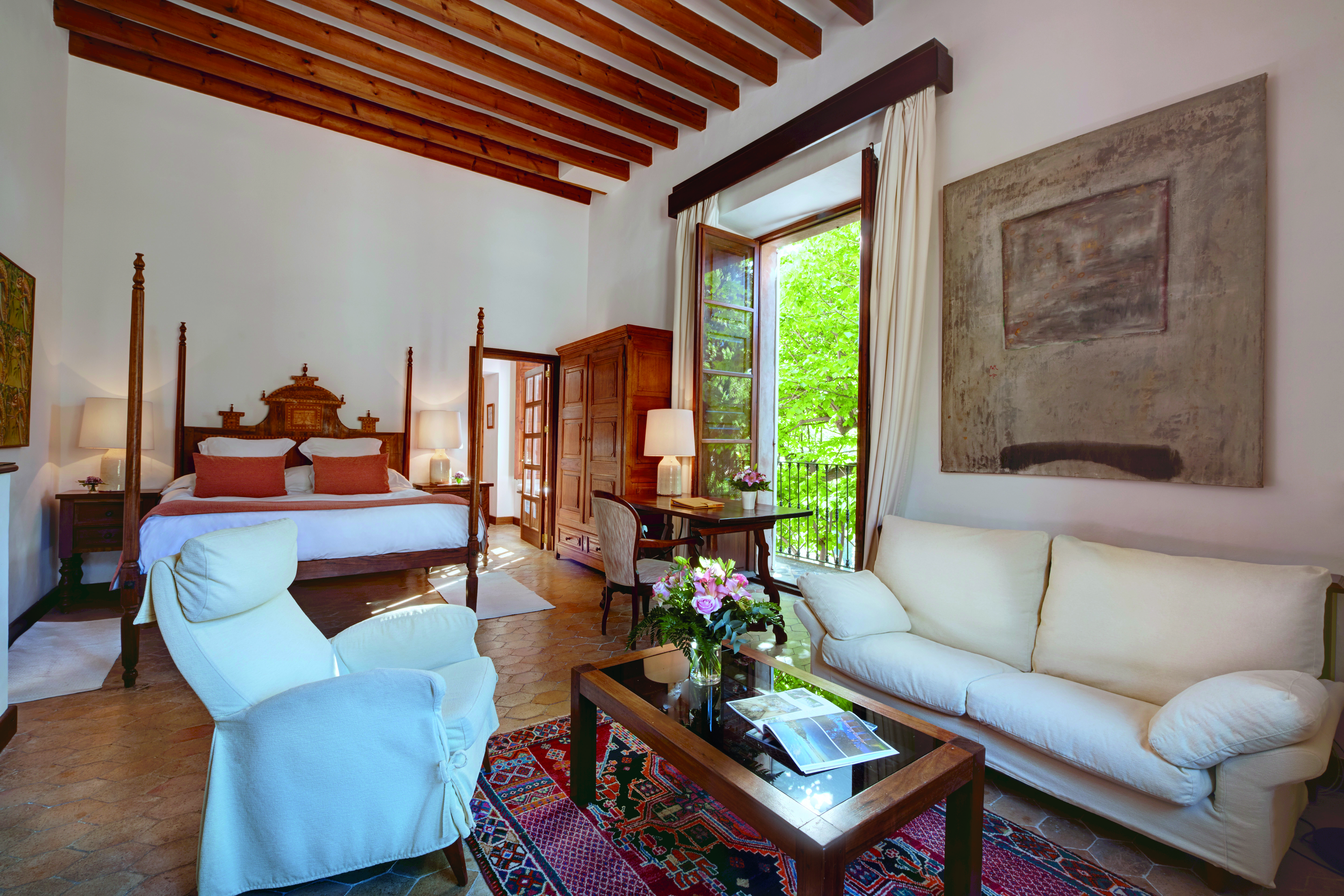 La Residencia Mallorca double superior bedroom carved four poster bed sitting area lounge armchair balcony