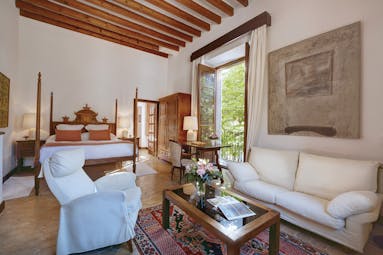 La Residencia Mallorca double superior bedroom carved four poster bed sitting area lounge armchair balcony