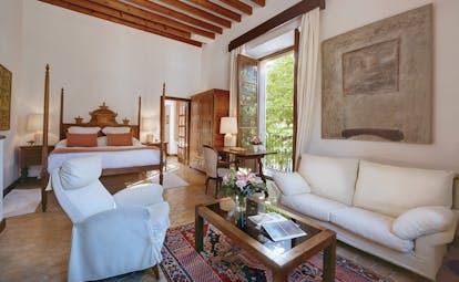 La Residencia Mallorca double superior bedroom carved four poster bed sitting area lounge armchair balcony