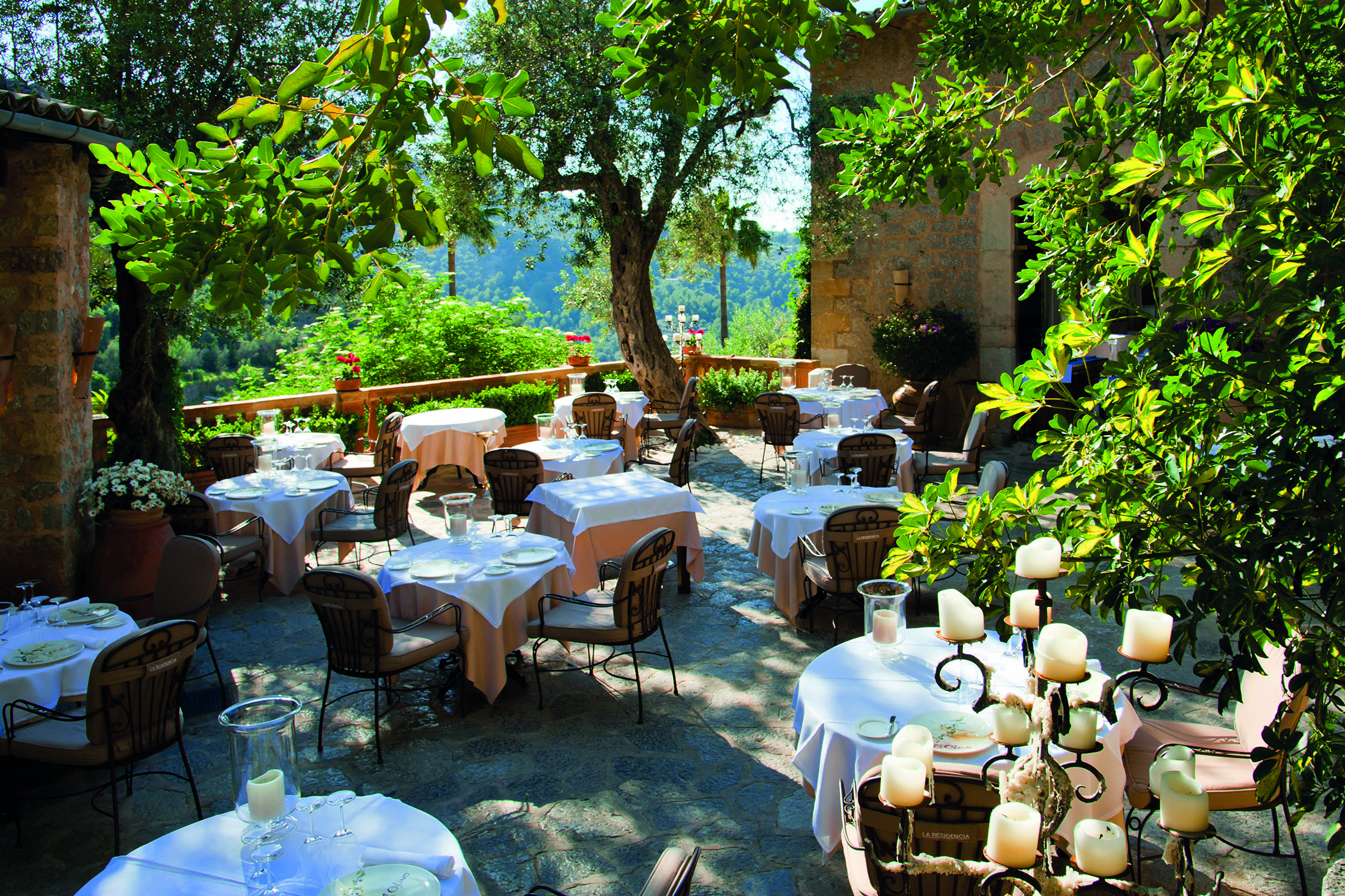 La Residencia Mallorca restaurant terrace dining area candelabras greenery trees