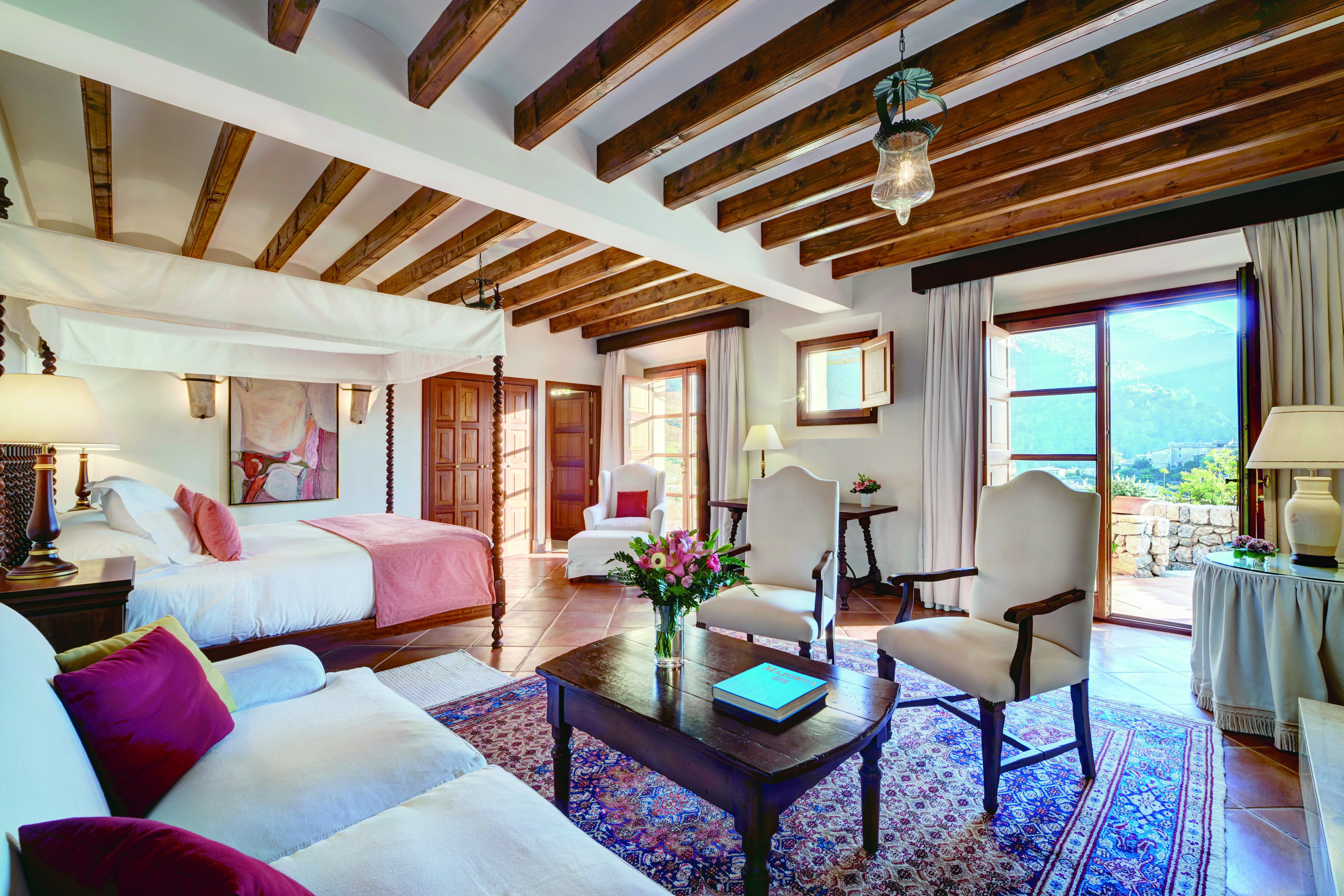 La Residencia Mallorca suite lounge area four poster bed classic modern decor mountain view
