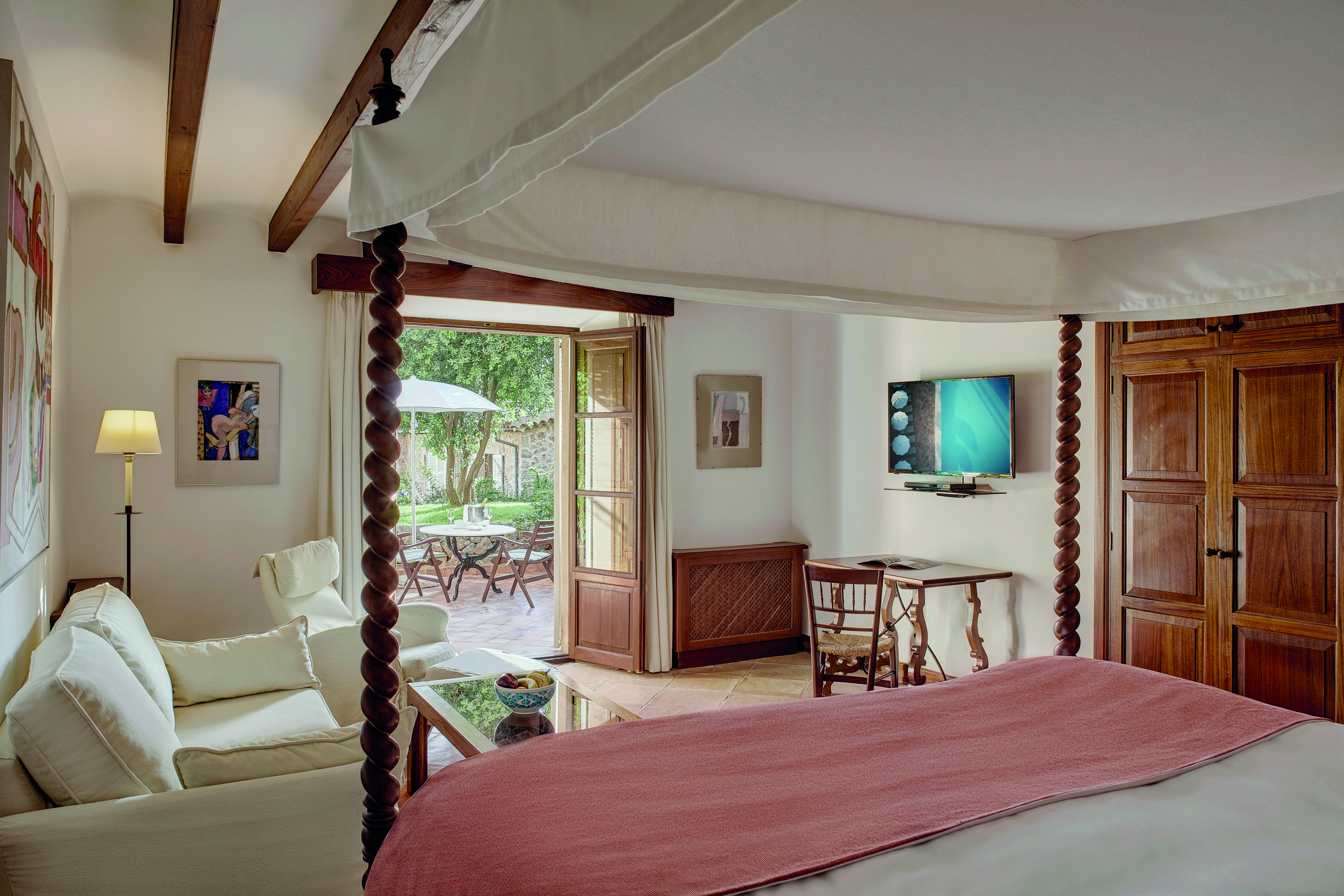 La Residencia Mallorca superior bedroom spiral four poster bed sofa patio area