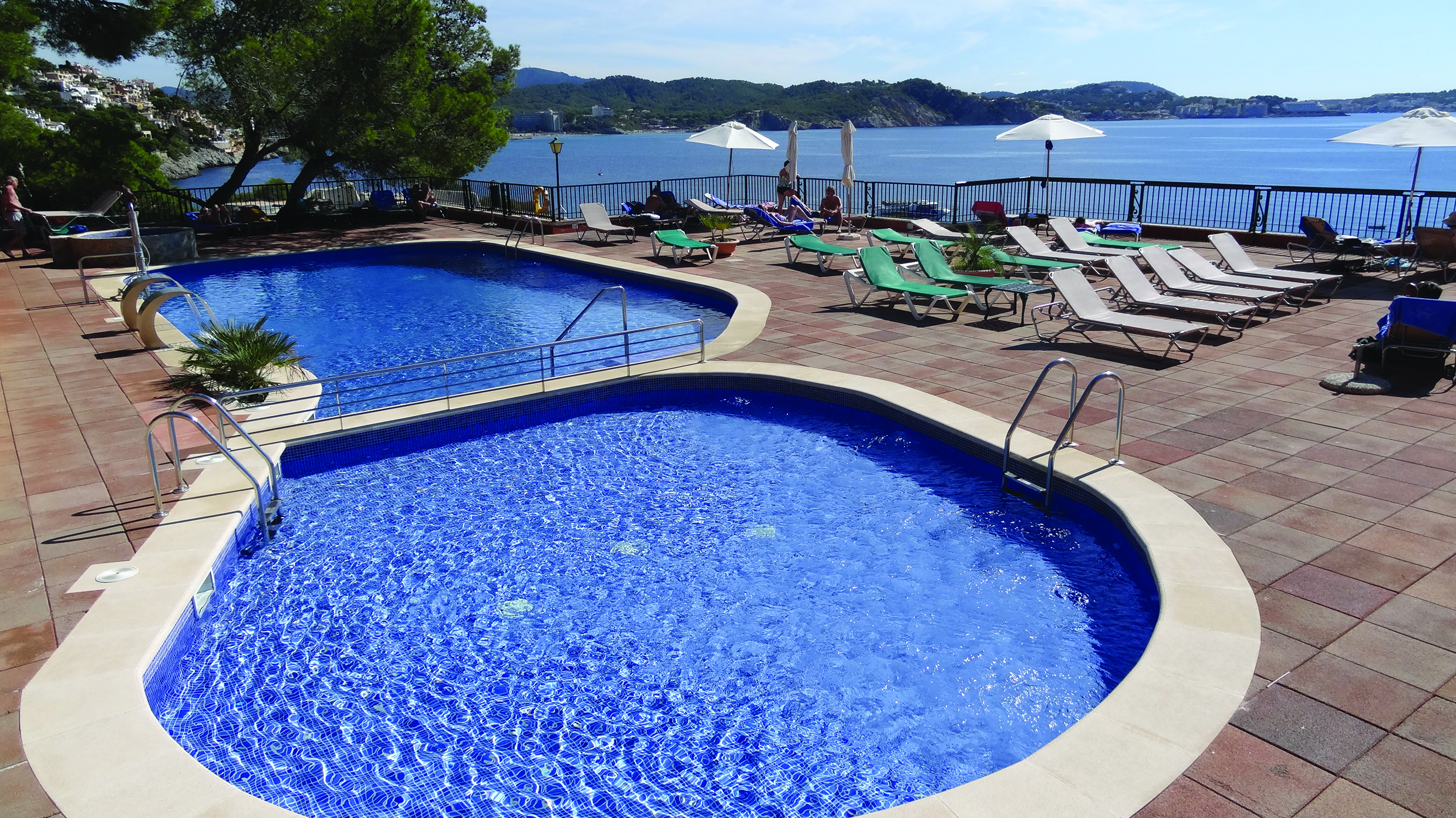 Cala Fornells Mallorca pool sun loungers umbrellas sea in background