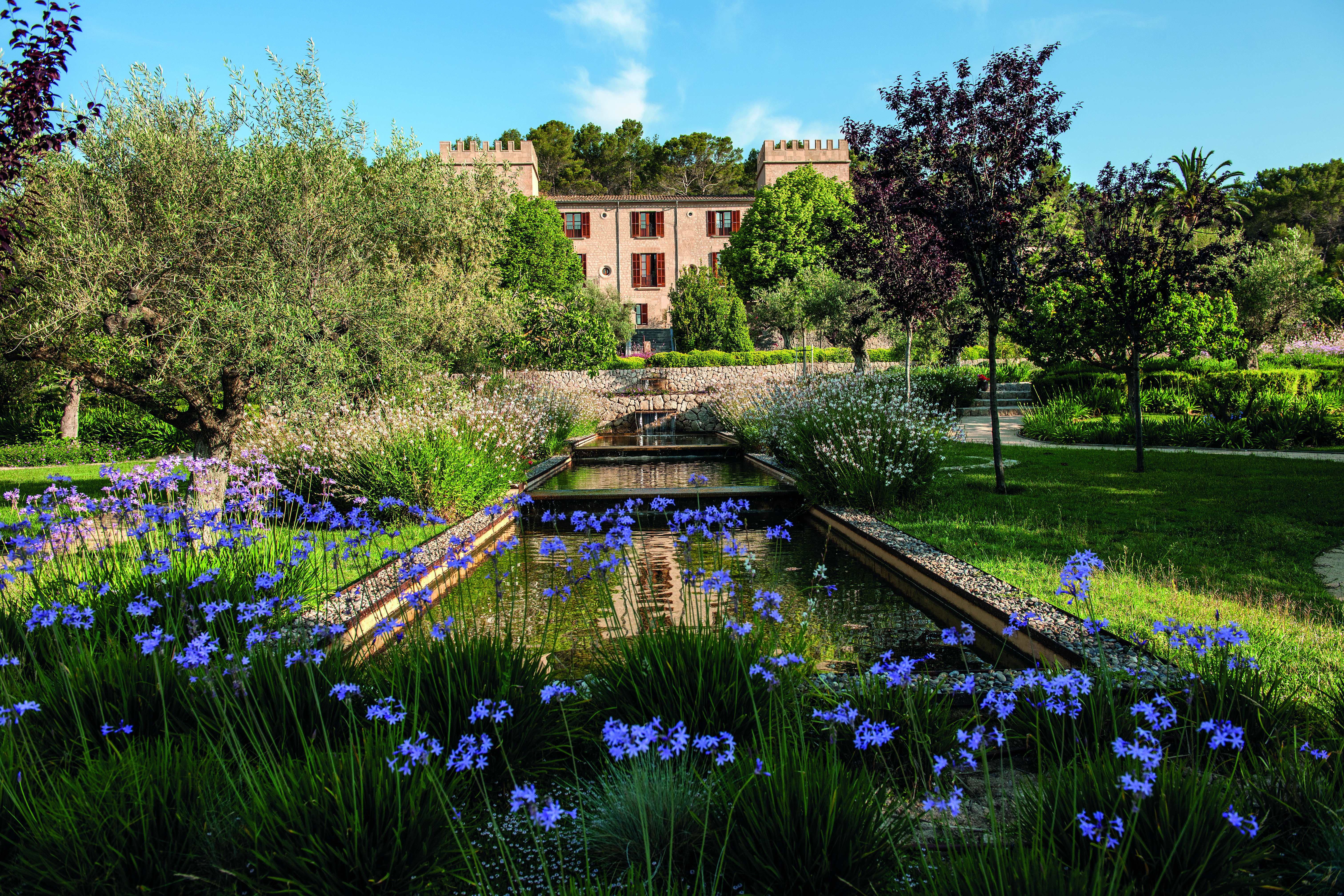 Castell Son Claret Mallorca front garden ponds lawns trees flowers hotel in background