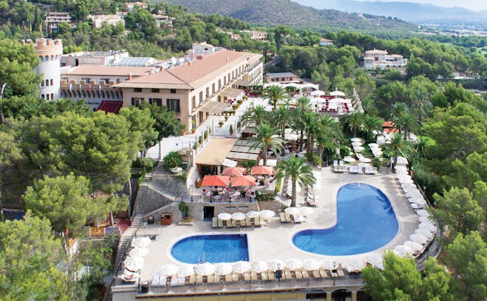 Aerial view of hotel and pool shown surrounded by trees