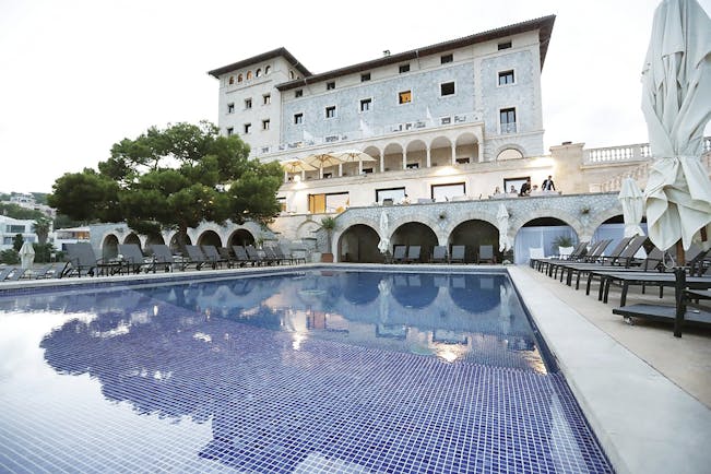 Hospes Maricel Mallorca pool sun loungers umbrellas hotel in background