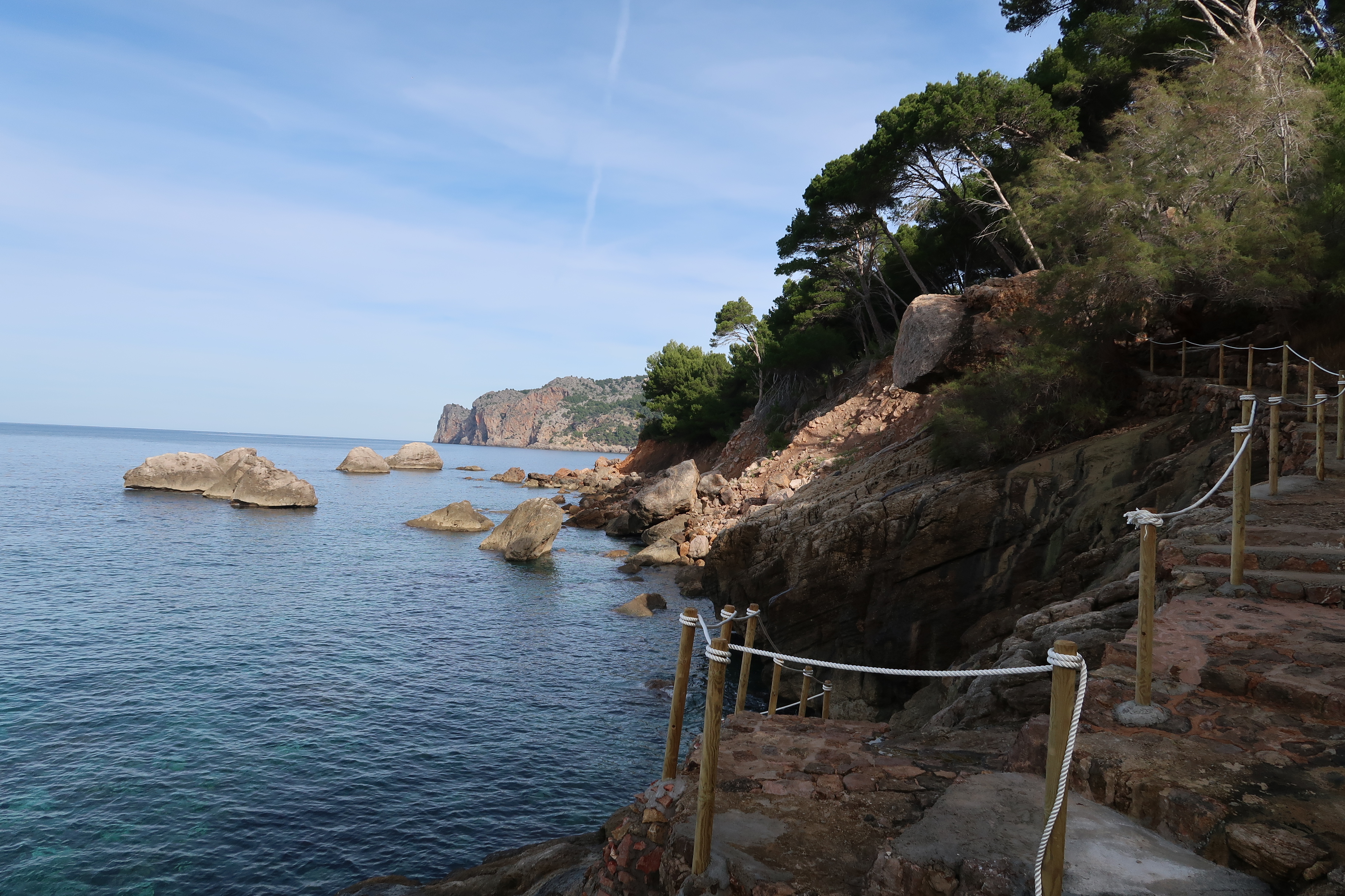 Hotel Hoposa Costa d'Or rocky coastline with rugged stone steps leading down from the green clifftops above