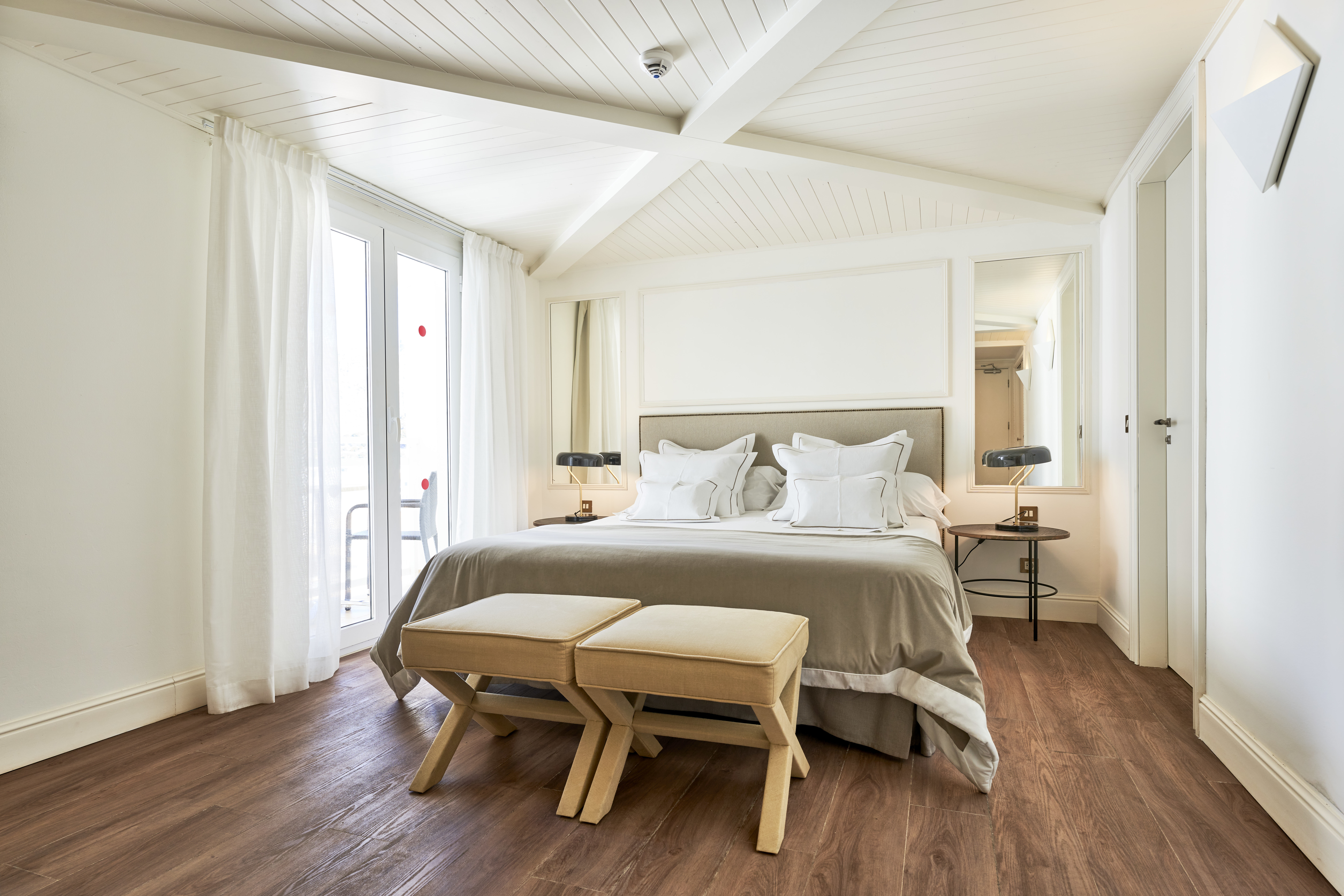 Hotel Hoposa Daina Standard room, in light neutral colours, with a large central bed and wooden floors