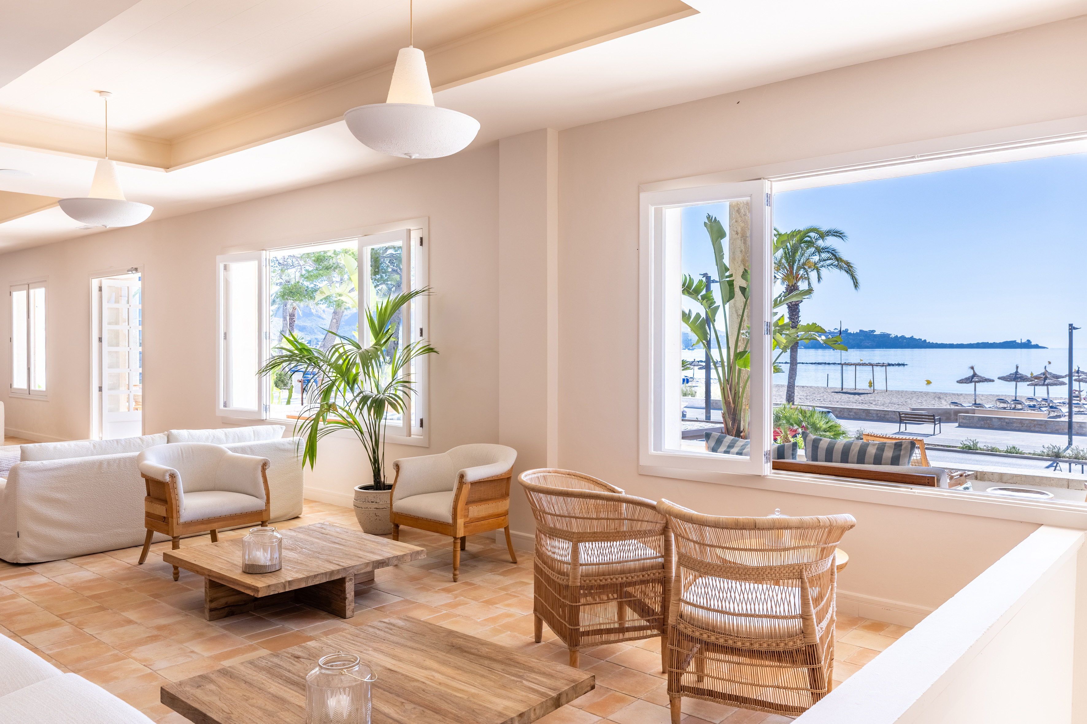 Hotel Hoposa Pollentia light bar area looking out over the pool, beach, and sea beyond