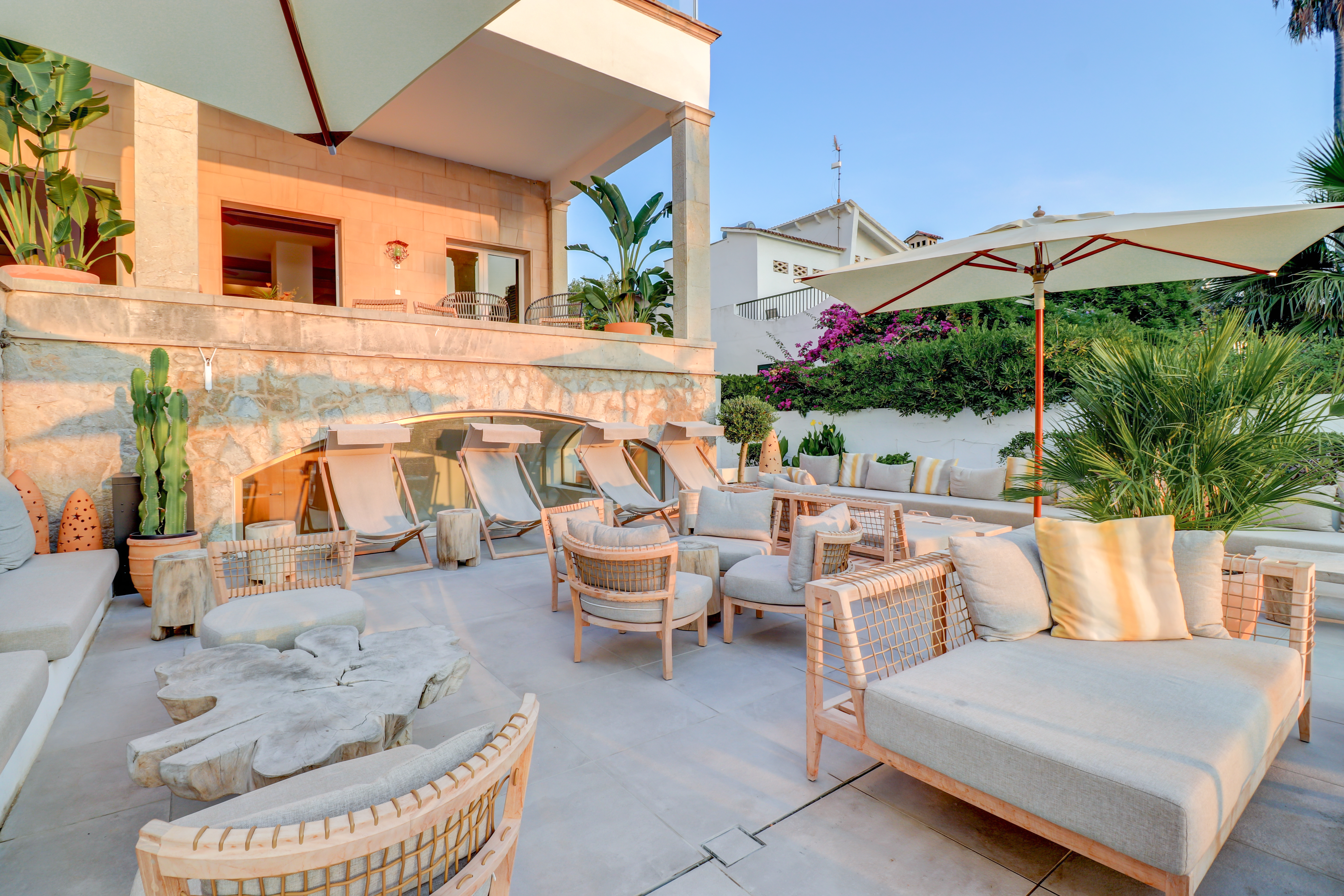 Hotel Hoposa Pollentia lower restaurant terrace with comfortable sofas, chairs, and parasols