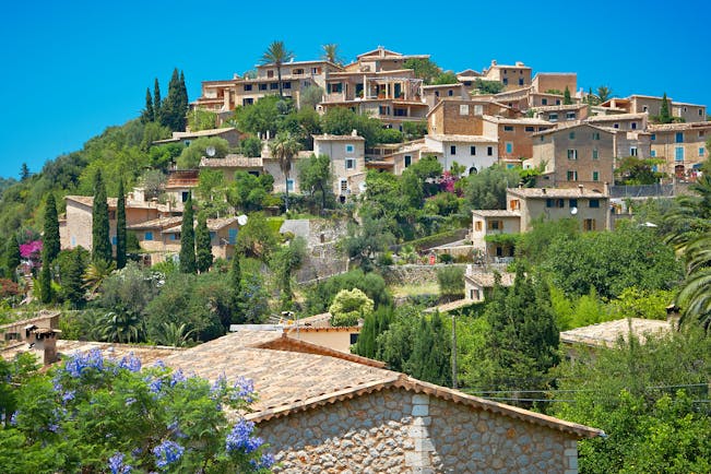 Hill-top village of Deia with its stone houses, olive trees and cypress trees in Mallorca