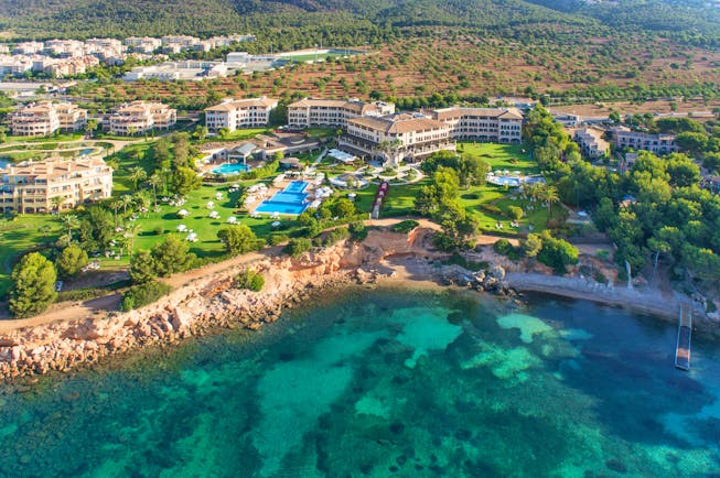 Birds eye view of resort showing proximity to cliff and ocean with large pools and buildings