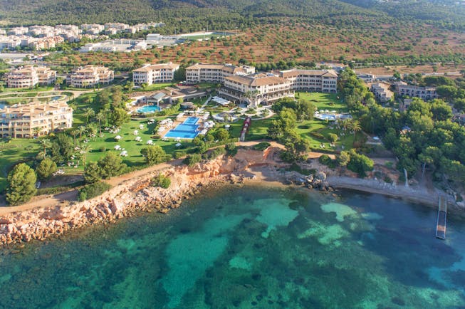 Birds eye view of resort showing proximity to cliff and ocean with large pools and buildings