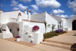 Torralbenc Menorca hotel exterior white buildings pink flowers pathways