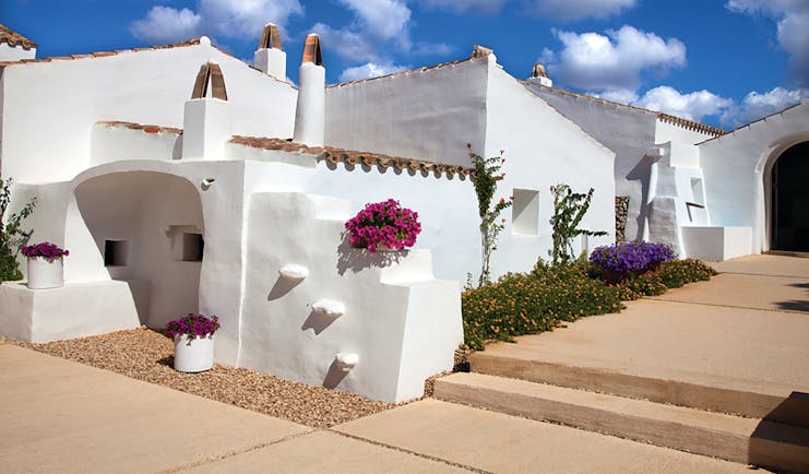 Torralbenc Menorca hotel exterior white buildings pink flowers pathways