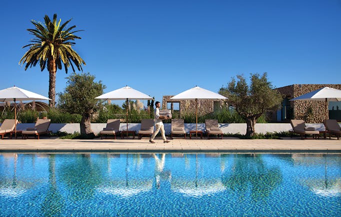 Torralbenc Menorca pool sun loungers umbrellas palm trees