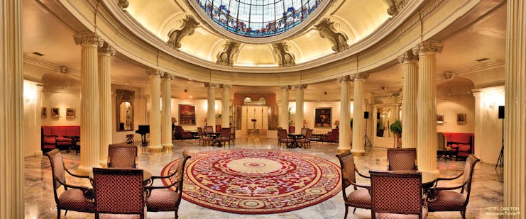 Lobby with high ceilings, seating area and column pillars