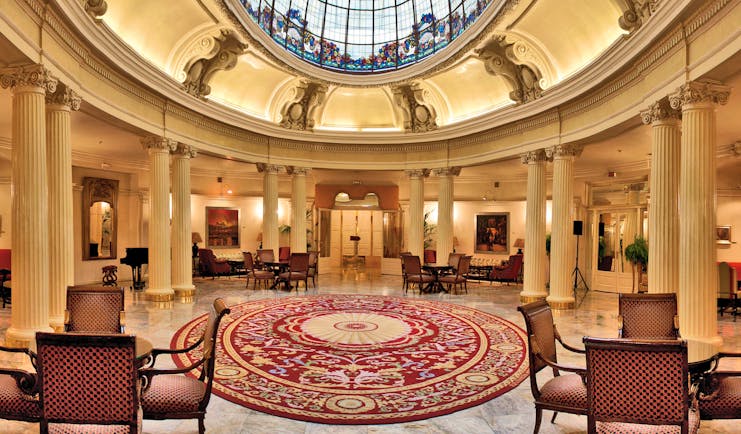 Lobby with high ceilings, seating area and column pillars