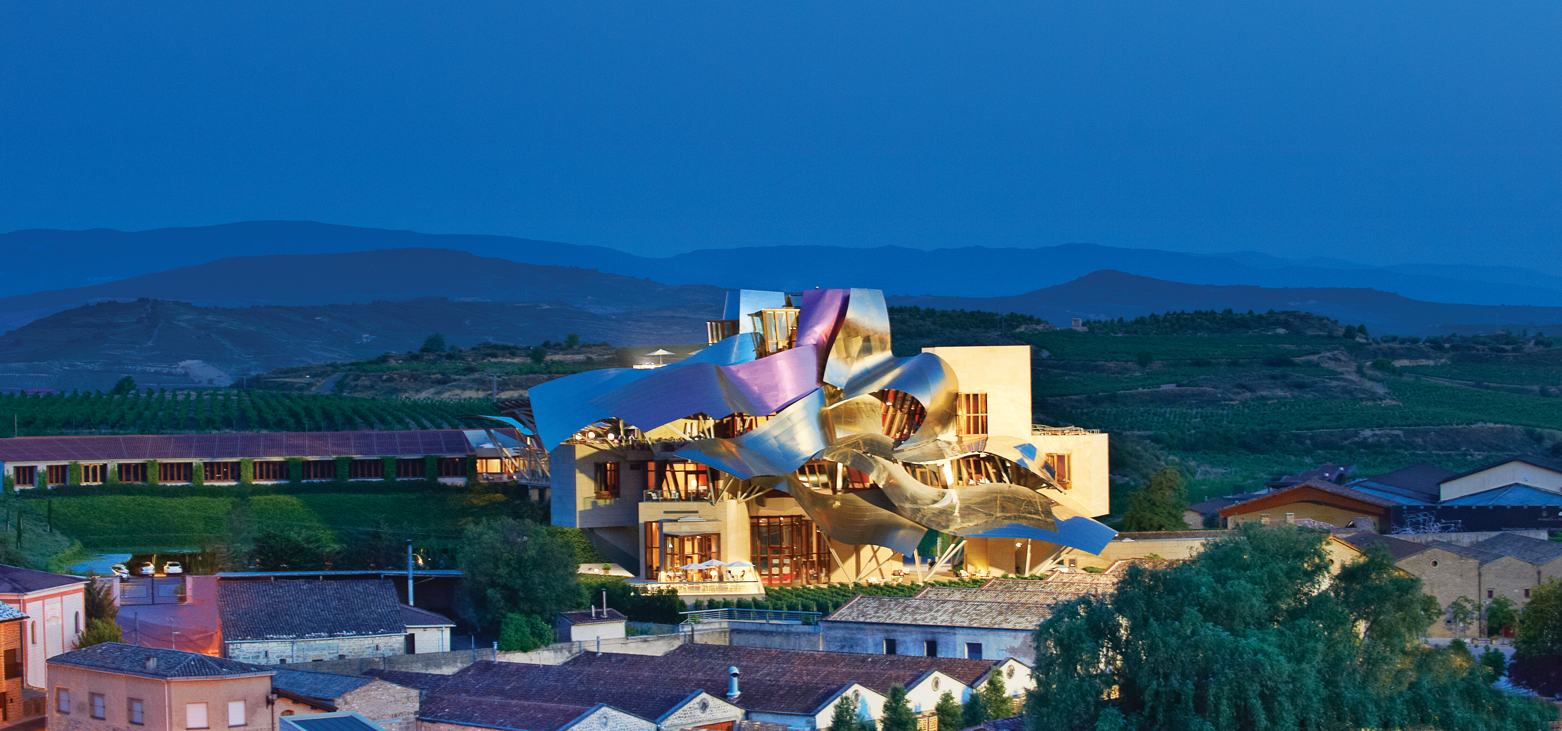Exterior of the hotel at night with decorative lit up hotel builidng