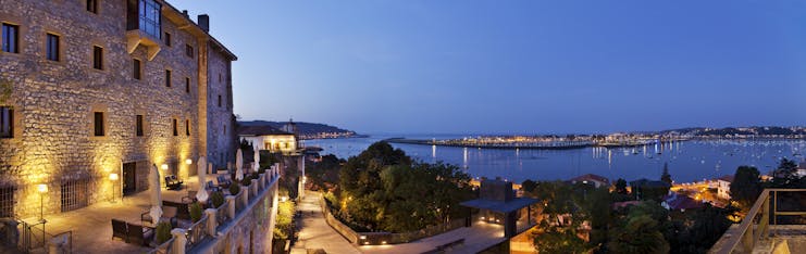 Panoramic view from the hotel with views over the ocean and stone buildings at dusk 