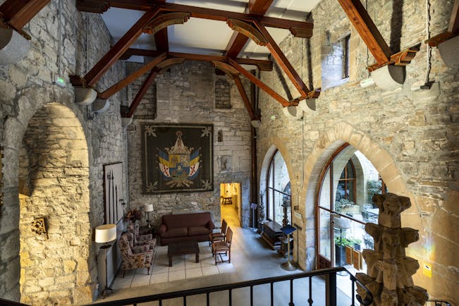 Reception area with large stone walls, arched doorways leading to an outdoor terrace and sofas inside