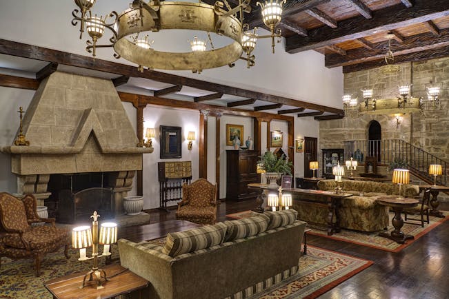 Lounge area with high ceilings, fireplace, large chandeliers, sofas and armchairs