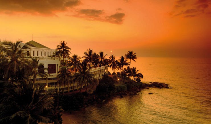 Mount Lavinia Hotel Sri Lanka exterior white hotel next to sea palm trees sunset
