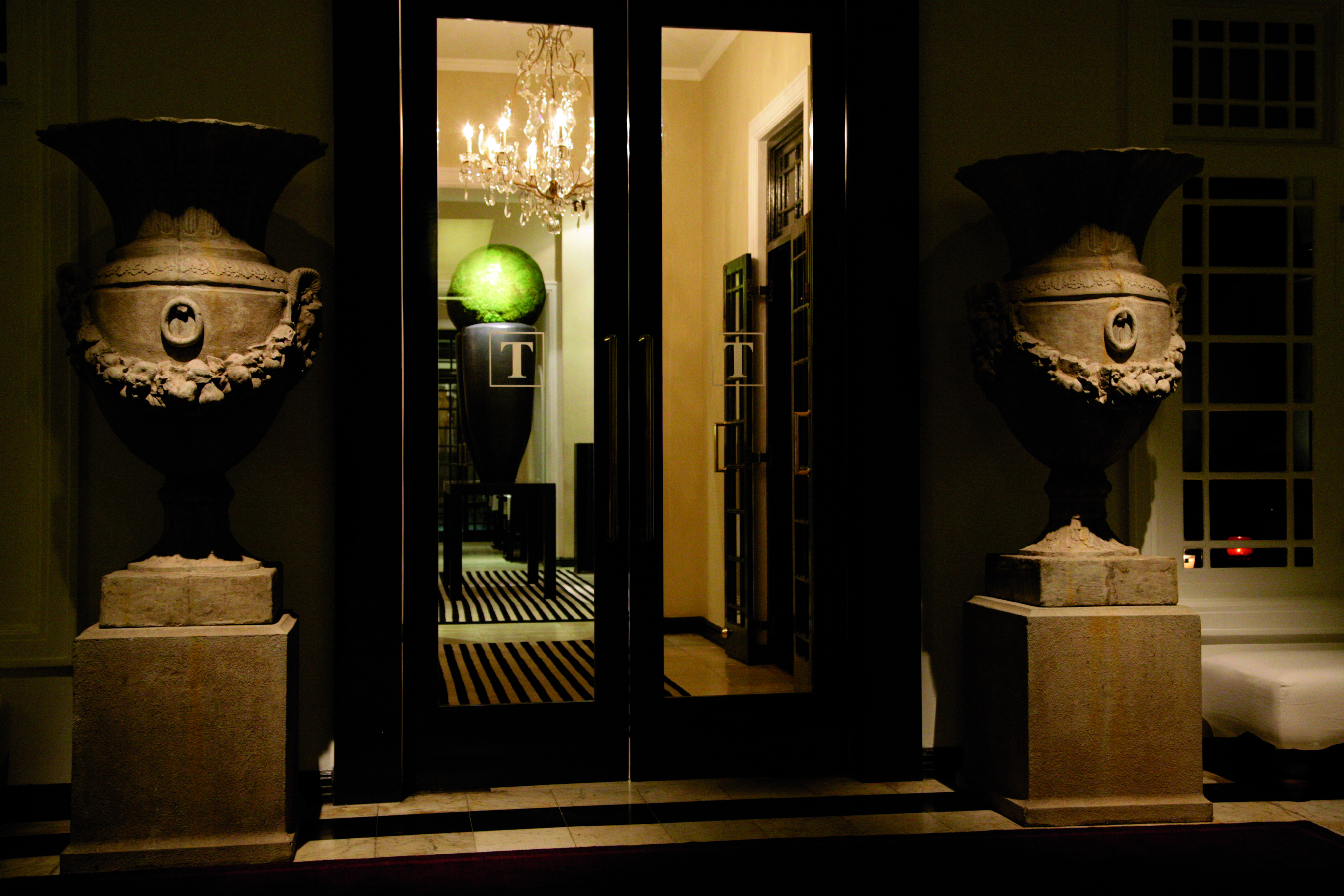 Paradise Road Tintagel suite entrance, black doors, stone statues of urns