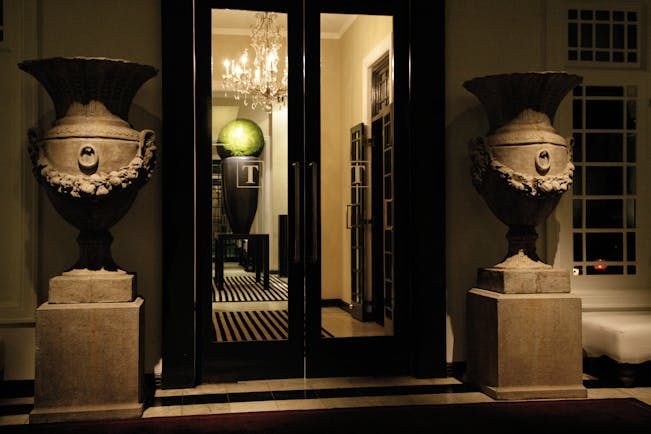 Paradise Road Tintagel suite entrance, black doors, stone statues of urns