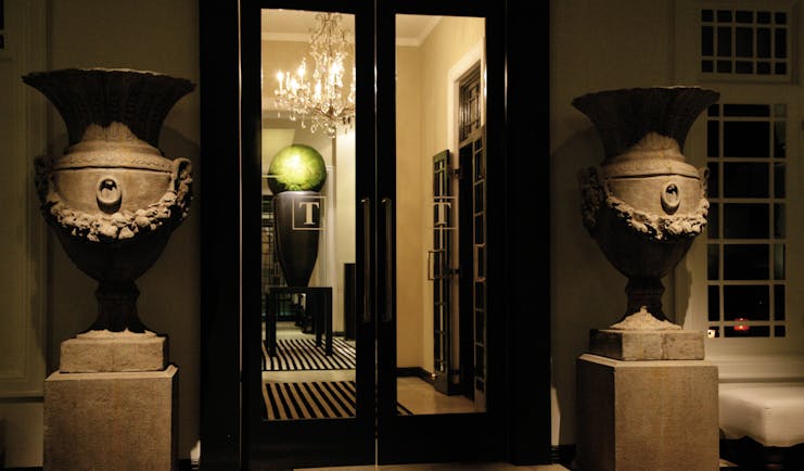 Paradise Road Tintagel suite entrance, black doors, stone statues of urns