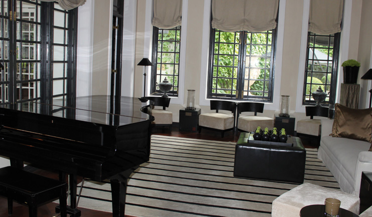 Paradise Road Tintagel lounge with sofas and chairs, piano, monochrome decor