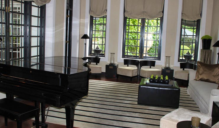 Paradise Road Tintagel lounge with sofas and chairs, piano, monochrome decor