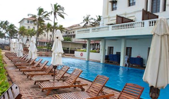 Galle Face Hotel Sri Lanka poolside wooden sun loungers and umbrellas