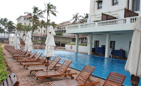 Galle Face Hotel Sri Lanka poolside wooden sun loungers and umbrellas