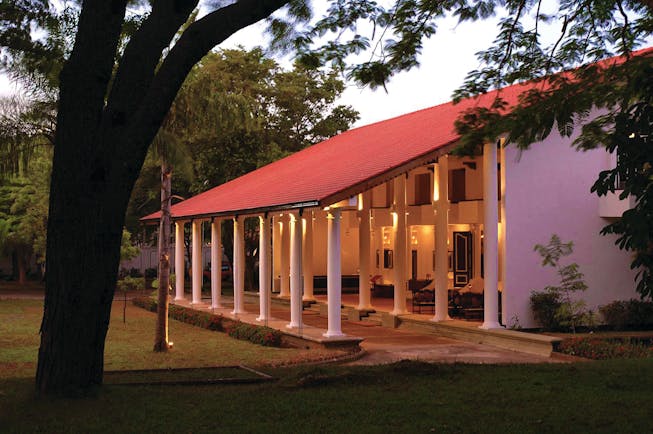 Cinnamon Lodge Sri Lanka nighttime sloping roof red and white colonnaded building