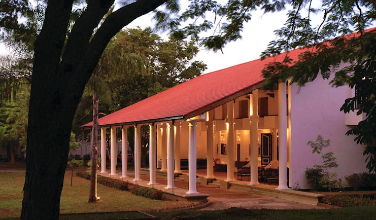 Cinnamon Lodge Sri Lanka nighttime sloping roof red and white colonnaded building