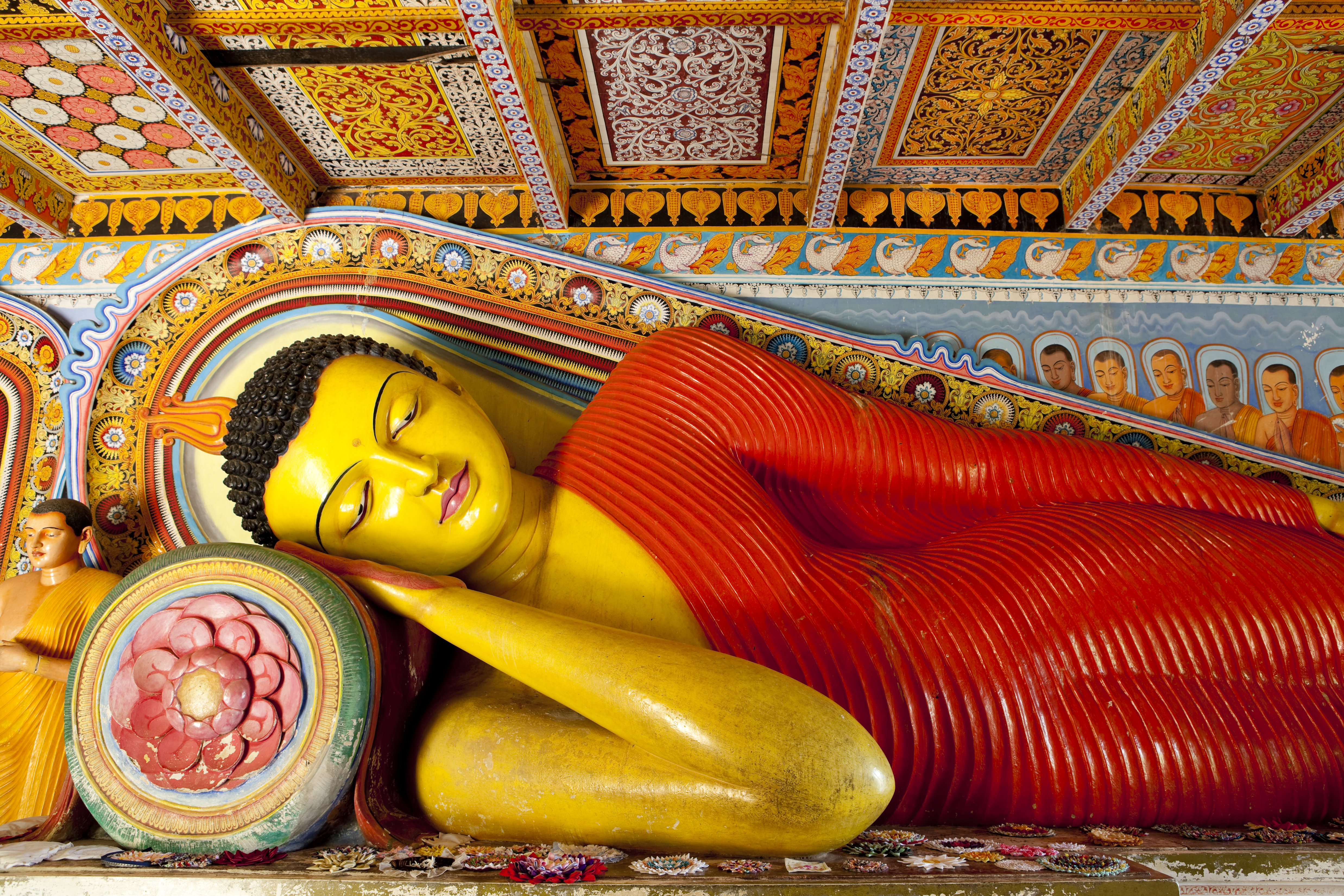 Isurumuniya temple in the Cultural Triangle, colourful buddha statue of Buddha reclining, intricate details